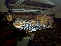 At the concert by the Vatican. We're sitting along the side of the hall, the audience is applauding a guest violinist.