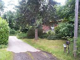 The house as seen from the street.  I actually live at the end of a dead-end street, you can see where my driveway begins.