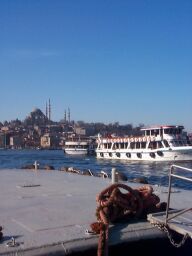 Ferries maneuvering in the Golden Horn, a mosque in the background.