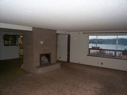 The living room.  Note the carpet, sparkly ceiling, and brown accordian doors on either side of the fireplace.