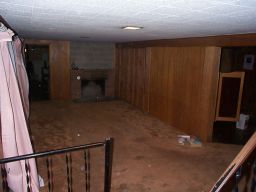 Downstairs, looking from the stairwell into the large downstairs room.  Acoustic tile ceiling, and swinging doors.